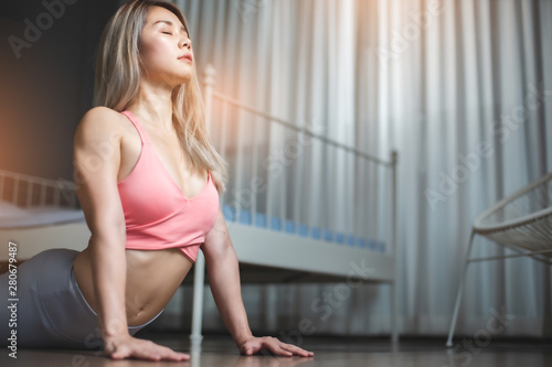 Young woman practicing yoga in gray background.Young people do yoga indoor at home.