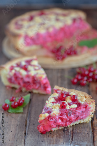  A pieces of red currant pie on wooden background. Out of focus pie.