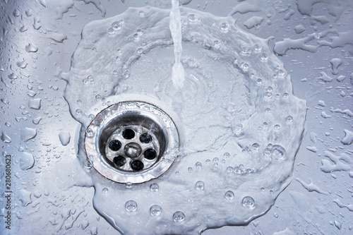 Water draining at sink background. Water flowing drain in washbasin