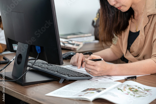 Closeup Asian Businesswoman in formal suit writeing and working with computer in office, business and technology workplace concept