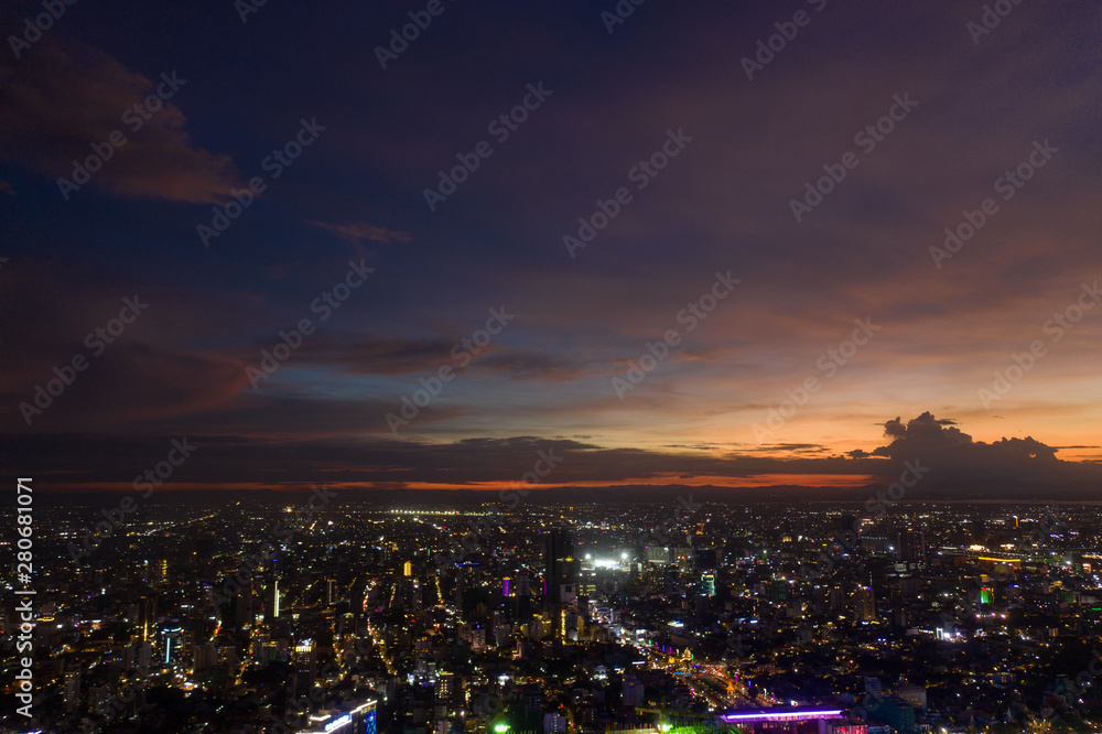 Naklejka premium Top View of Building in a City - Aerial view Skyscrapers flying by drone of Phnom Penh city with riverside , Palace and small island in sunset