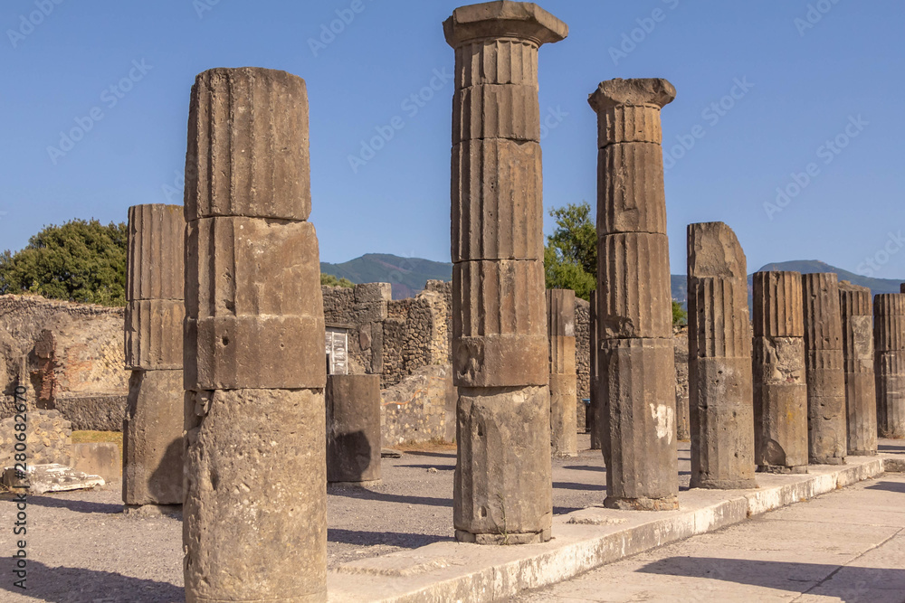 Pompeii ruins: stone columns at archeological site. Remains of the ancient Pompeii town destroyed by eruption of volcano Vesuvius, Italy