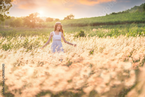Beauty Girl Outdoors enjoying nature. Beautiful Teenage Model girl in white dress running on the Spring Field, Sun Light.