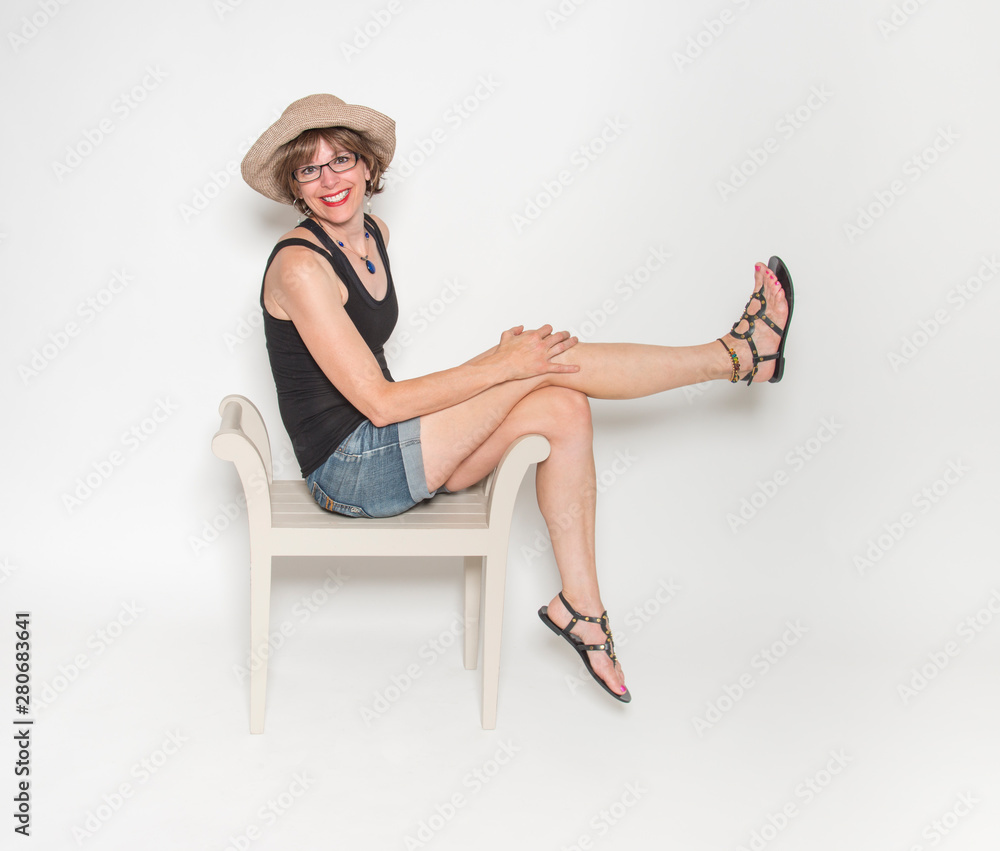 Smiling happy middle aged woman sitting isolated on white background Smiling happy middle aged woman sitting isolated on white background