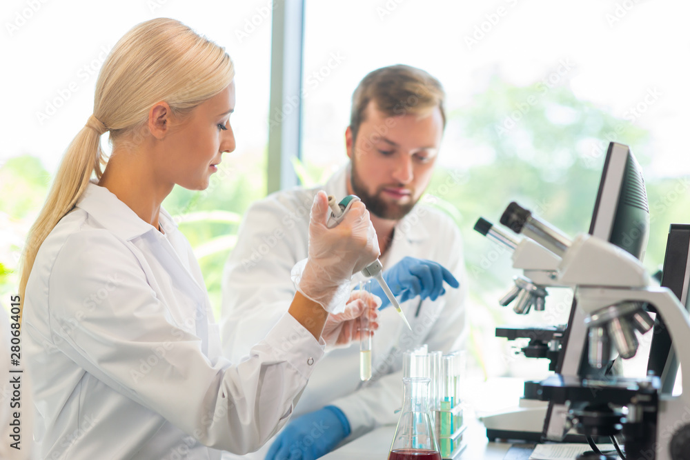 Scientist and students working in lab. Doctor teaching interns to make analyzing research. Biotechnology, chemistry, bacteriology, virology, dna and health care concept. Scientist and students working in lab. Doctor teaching interns to make analyzing research. Biotechnology, chemistry, bacteriology, virology, dna and health care concept.
