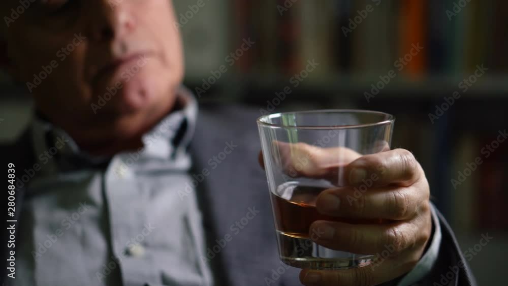 Depressed Old Alcoholic Businessman in Suit Sitting at Home With Whiskey Glass - Dramatic Lighting Depressed Old Alcoholic Businessman in Suit Sitting at Home With Whiskey Glass - Dramatic Lighting