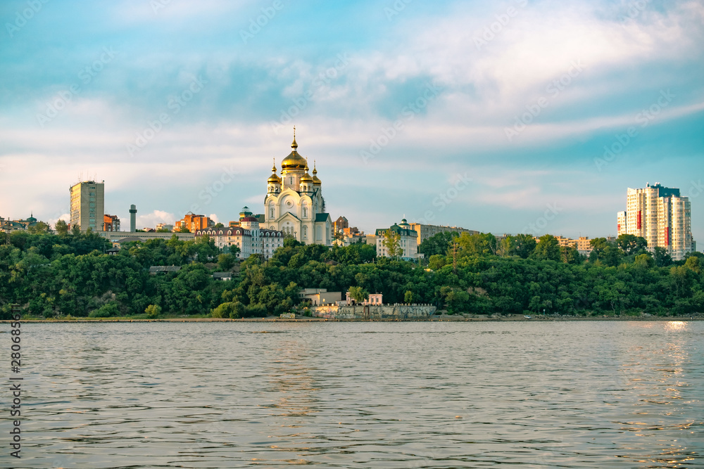 Obraz premium View of the city of Khabarovsk from the Amur river. Urban landscape in the evening at sunset.