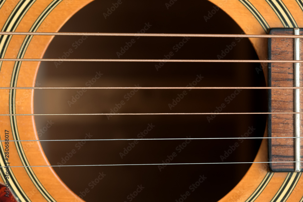 Obraz premium close macro view of the six frets and sound hole on an acoustic wooden guitar