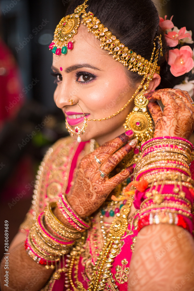 Portrait Of Beautiful Asian Indian Bride Wearing Ethnic Traditional Outfit And heavy Gold Jewellery Necklace Smiling wedding day