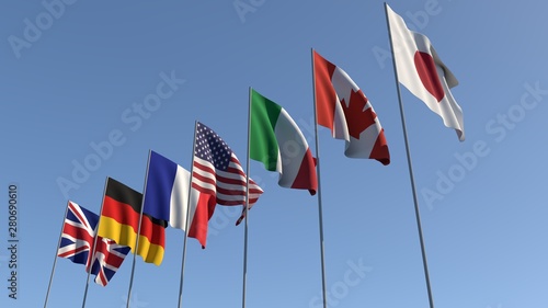 Seven flags of the Group of Seven are developing against the blue sky. G7