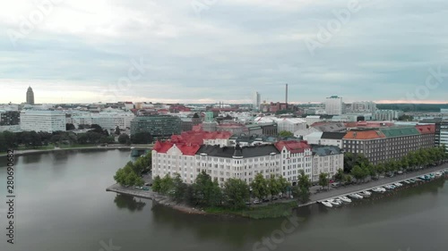 Aerial, drone shot, over Kaisaniemenlahti, panning around buildings in Siltasaari and Hakaniemi, on a cloudy, summer day, in Helsinki, Uusimaa, Finland photo