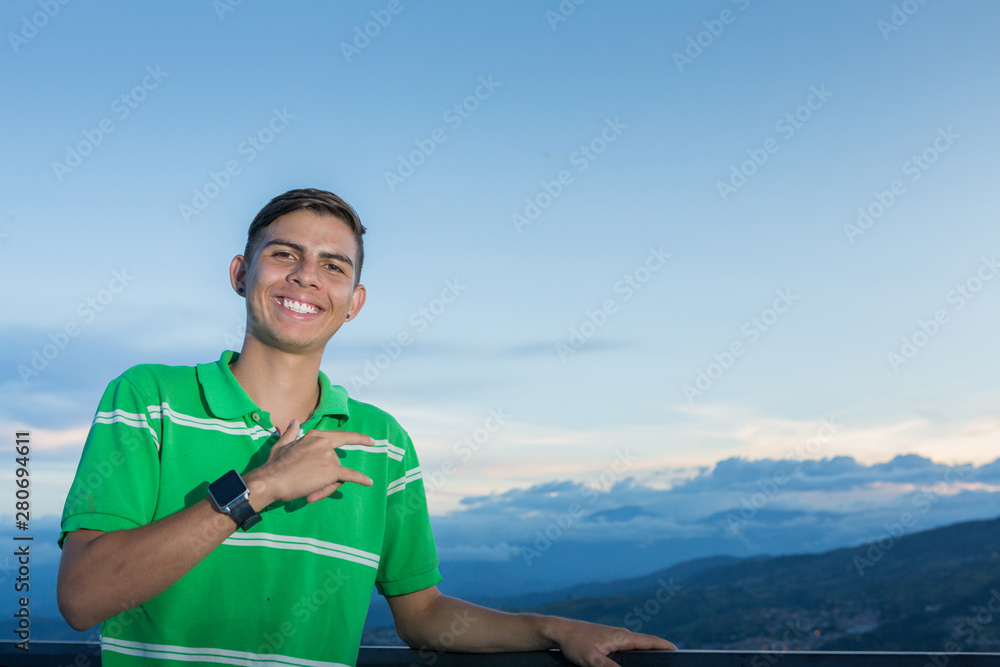 Young guy portrait outdoors. He signals that everything is OK.