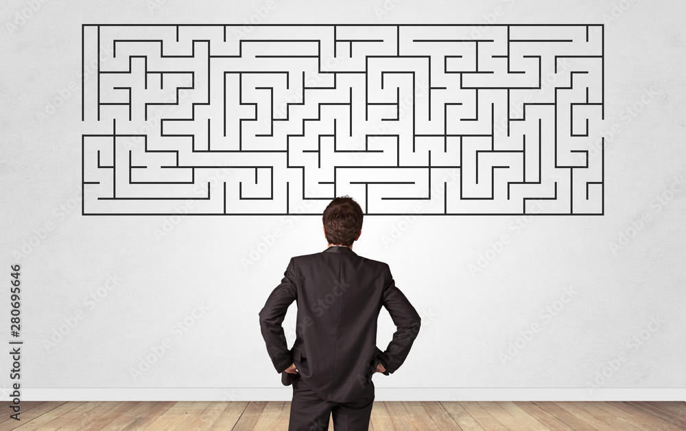 Businessman in doubt looking to a maze and searching the way out Businessman in doubt looking to a maze and searching the way out