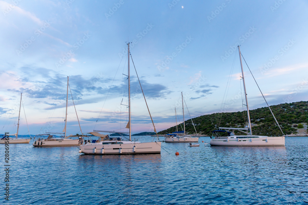 calm bay at evening with moored yachts