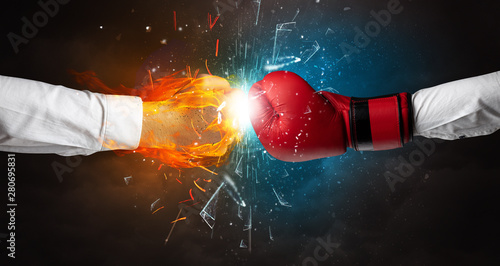 Two hands fighting and breaking glass into small pieces with fire and water concept © ra2 studio