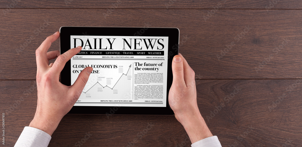Hand with tablet reading news on tablet Hand with tablet reading news on tablet