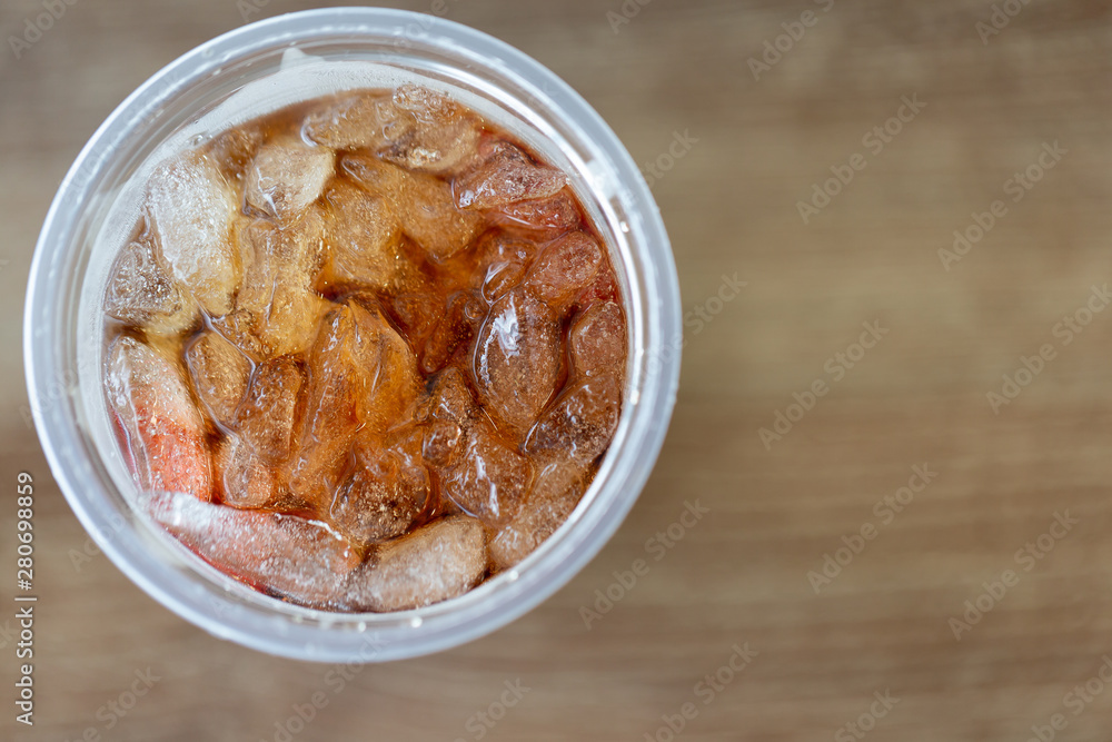 Close up of ice cubes with cola in the plastic glass,top view Close up of ice cubes with cola in the plastic glass,top view
