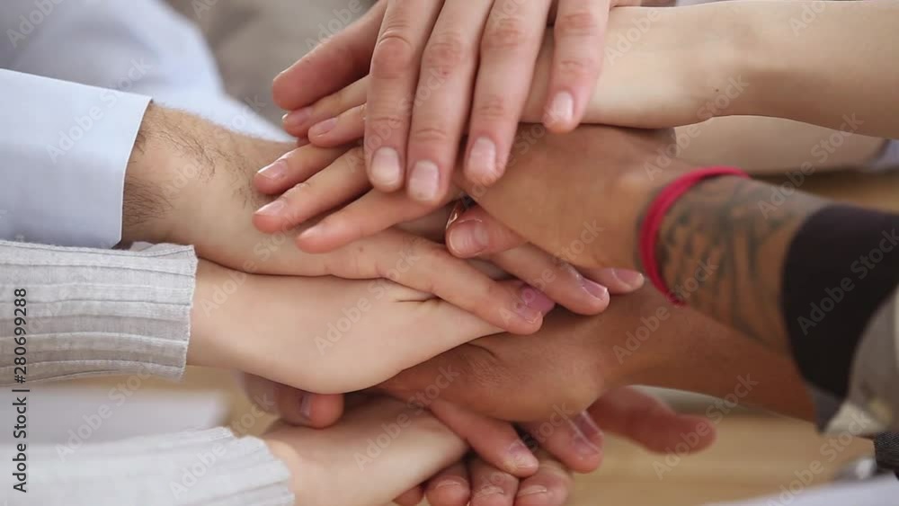 Different ethnicity people hands stacked together close up view Different ethnicity people hands stacked together close up view