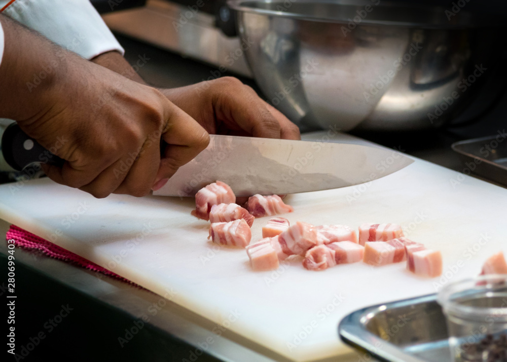 chef slice pork  belly and cutting in kitchen restaurant, Streaky pork or pork belly