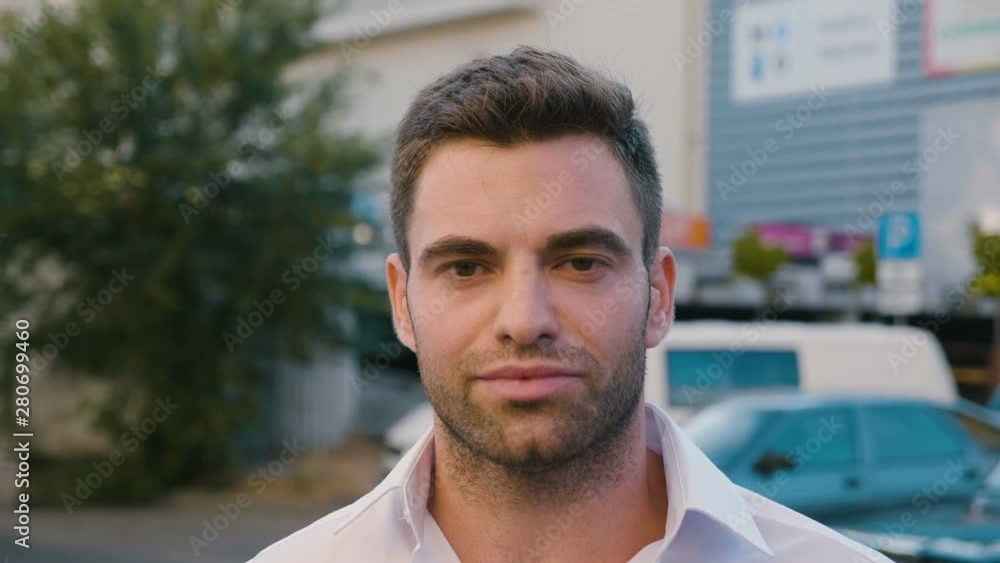 Close up portrait successful young businessman in city enjoying professional urban lifestyle. Handsome male employee looking at camera and smiling Close up portrait successful young businessman in city enjoying professional urban lifestyle. Handsome male employee looking at camera and smiling