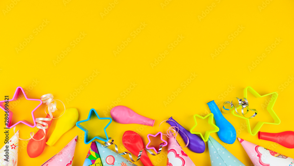Birthday party caps, balloon and stars on yellow background. Colorful celebration background with various party. Birthday party caps, balloon and stars on yellow background. Colorful celebration background with various party.
