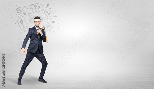 Young businessman in suit fighting with doodled symbols concept