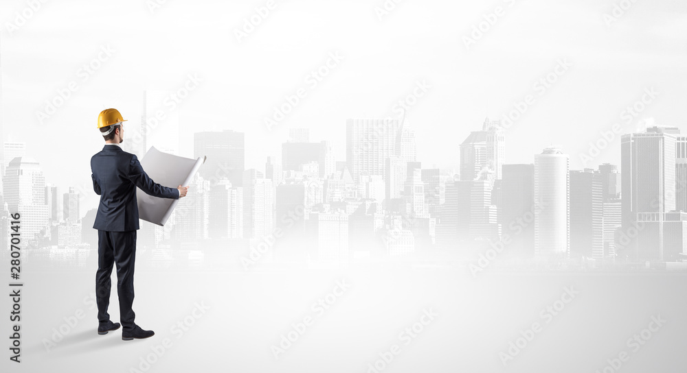 Young supervisor architect standing and looking at a big city panorama Young supervisor architect standing and looking at a big city panorama