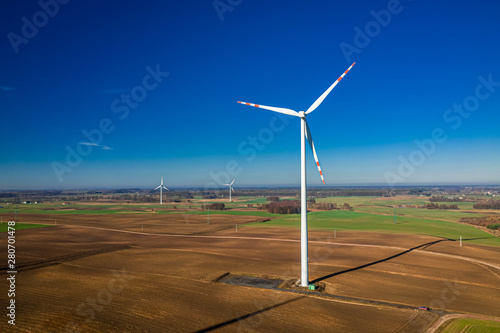 White wind turbines in a field, aerial view of Poland