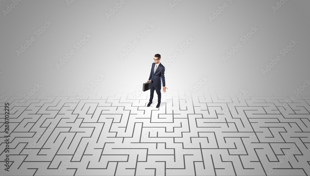 Elegant businessman looking for a solution in a middle of a maze Elegant businessman looking for a solution in a middle of a maze