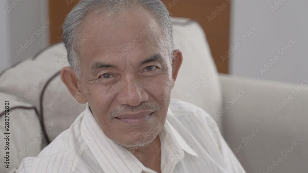 asian senior oldman sitting on the sofa smile when look at the camera asian senior oldman sitting on the sofa smile when look at the camera