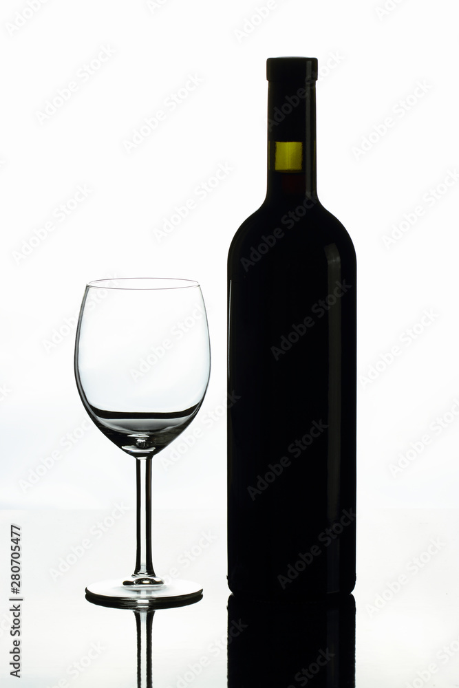 A bottle of red wine and a glass on a white background