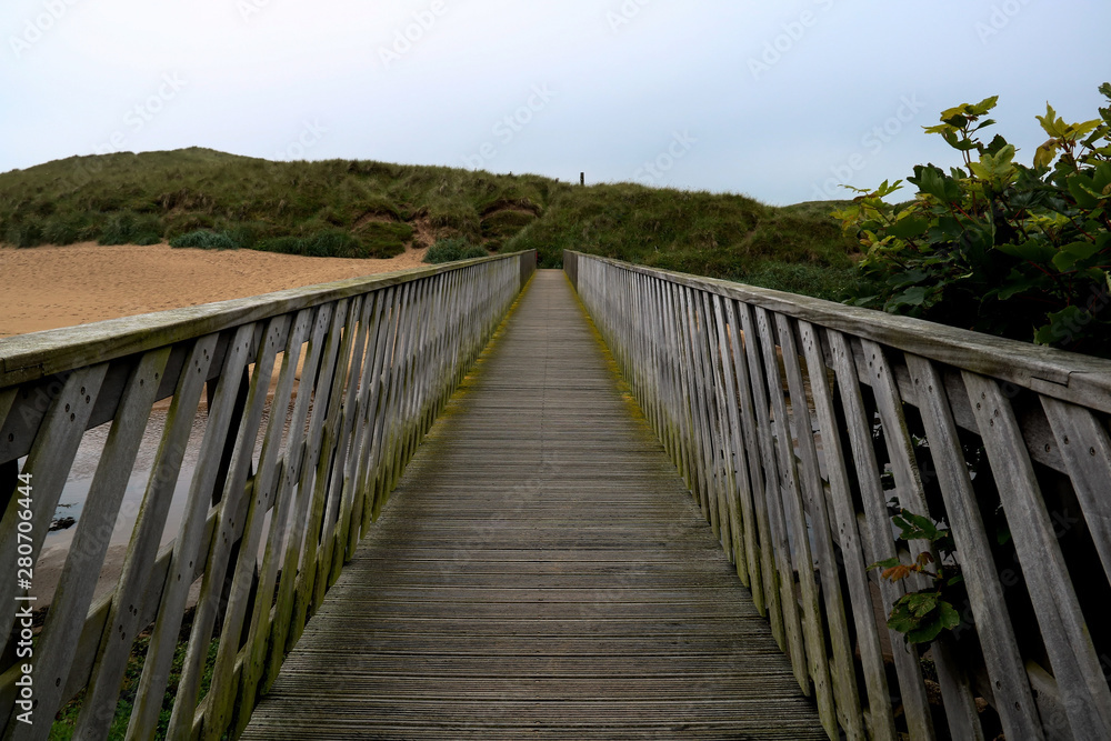 Wooden Footbridge Over a River Estuary to the Beach Wooden Footbridge Over a River Estuary to the Beach