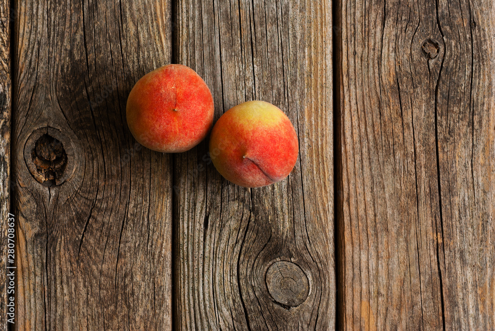 two peach fruits on old weathered wooden table background two peach fruits on old weathered wooden table background