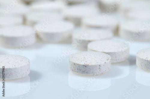 White pills on white background. Close up