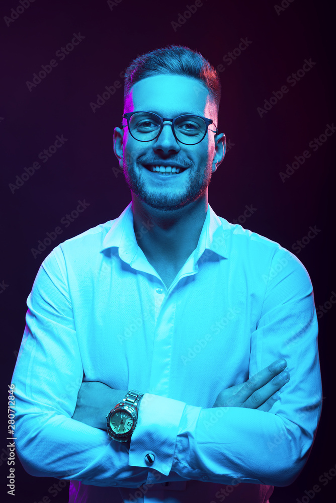 Young handsome model posing in a studio in a trendy neon light. Fashionable man in a stylish suit. Vibrant color. Bright colorful light effects. Disco style. Overlay. Gel filter. Supersaturated Young handsome model posing in a studio in a trendy neon light. Fashionable man in a stylish suit. Vibrant color. Bright colorful light effects. Disco style. Overlay. Gel filter. Supersaturated
