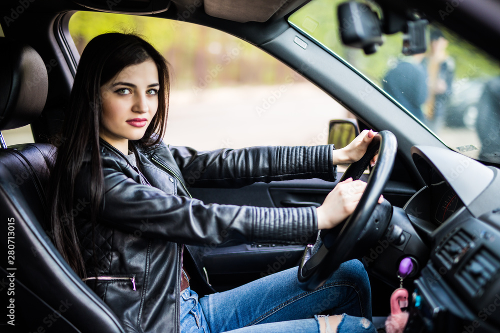 Portrait of beautiful young woman in new car, driving her automobile first time, beeps. Portrait of beautiful young woman in new car, driving her automobile first time, beeps.