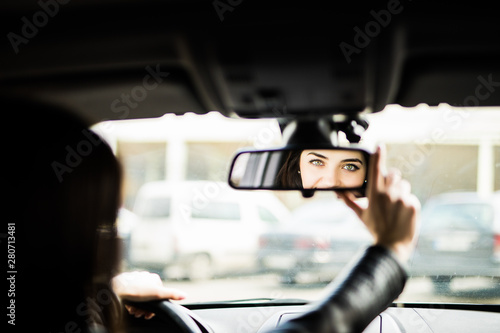 Obraz na plátne Rear view of attractive young woman in casual wear looking in rear-view mirror a