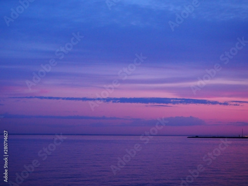 Twilight multi-colored pink and blue sky at the sunset with colorful reflection in the sea water. Panoramic marine landscape on the dusk.