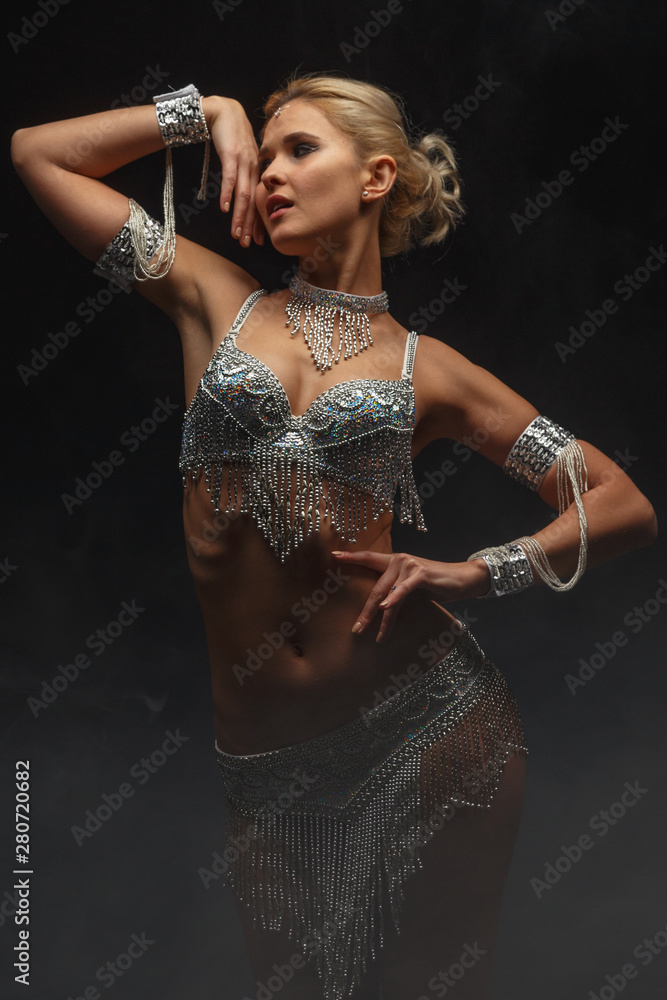 Slender girl blonde in a beautiful costume dancing Oriental dance.