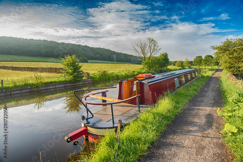 Fototapete Narrowboat moored on a British canal in rural setting