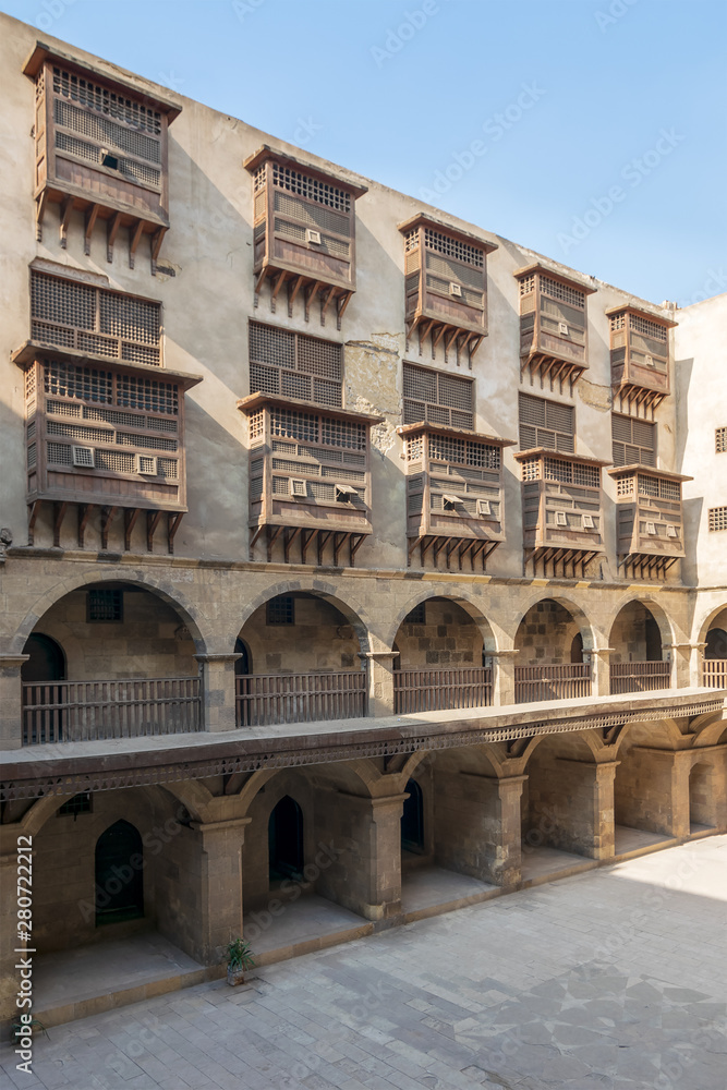 Facade of historic caravansary of Bazaraa, with vaulted arcades and windows covered by interleaved wooden grids suited in Gamalia district, Medieval Cairo, Egypt