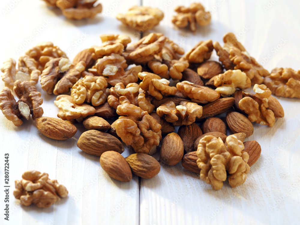 walnuts and almonds on a light wooden surface walnuts and almonds on a light wooden surface