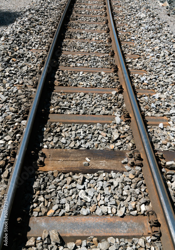 narrow gauge railroad tracks and rock bed close up view © makasana photo