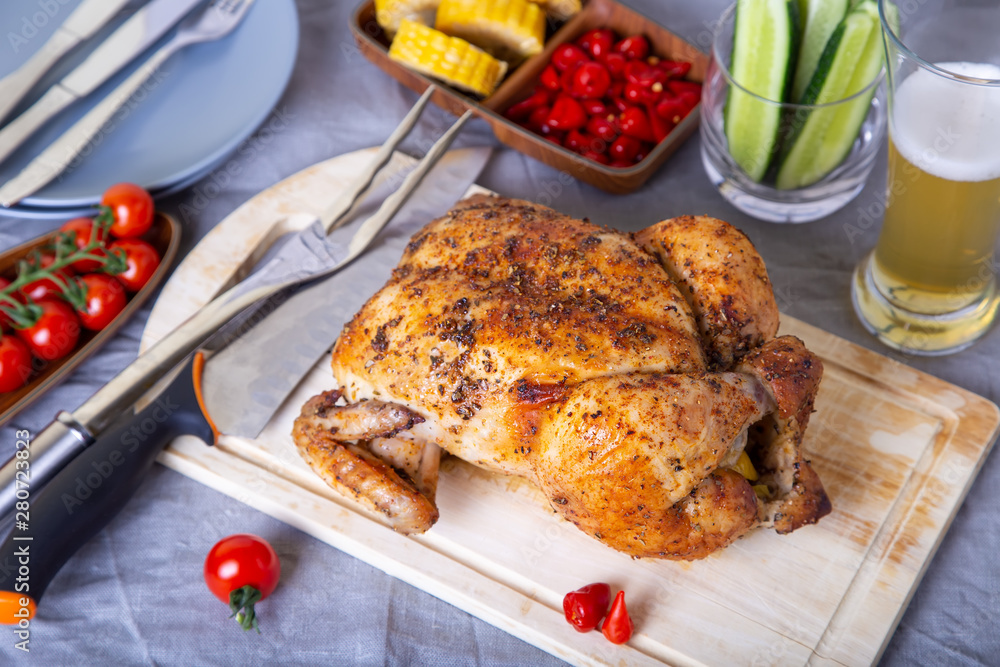 Chicken whole baked on salt. With corn on the cob, cherry tomatoes, cucumbers and jalapeno peppers. Selective focus, close-up. Chicken whole baked on salt. With corn on the cob, cherry tomatoes, cucumbers and jalapeno peppers. Selective focus, close-up.