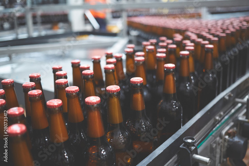 Beer bottles on the conveyor belt. Shallow dof. Selective focus.