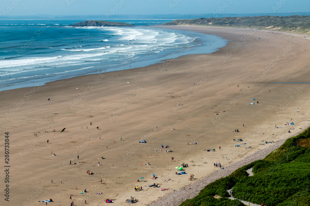 Surf and waves breaking on a huge, golden sandy beach Surf and waves breaking on a huge, golden sandy beach