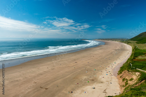 Surf and waves breaking on the beautiful golden sandy beach of Rhossili on the Gower Peninsula, Wales