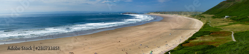 Aerial panorama of a huge golden sandy beach and ocean surf