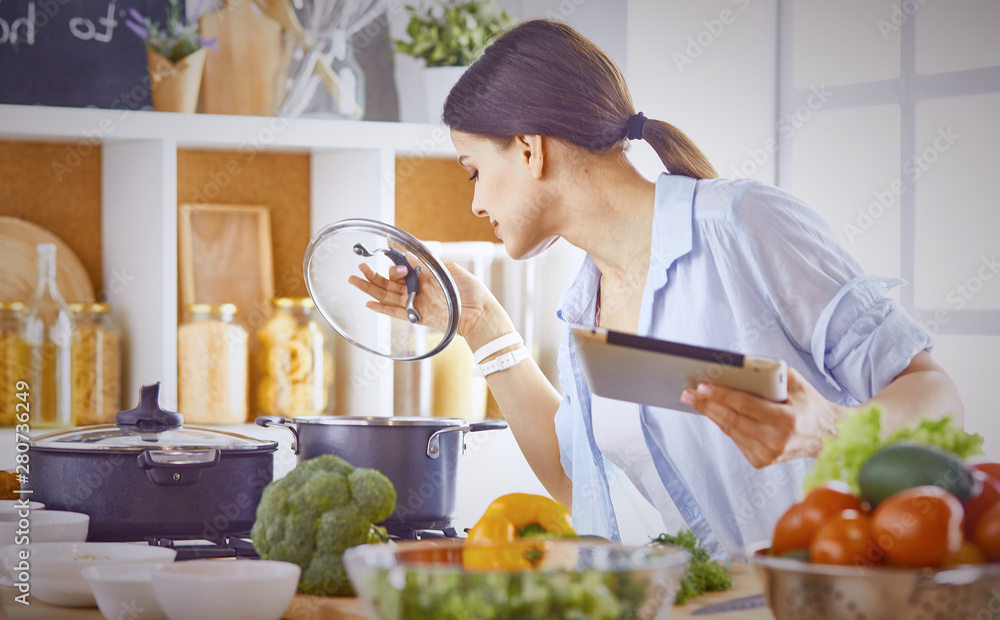 Image of a young pretty girl standing in the kitchen and is coo Image of a young pretty girl standing in the kitchen and is coo