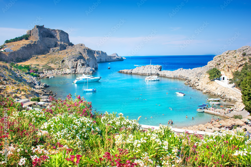 Lindos – panoramic view of St. Paul bay with acropolis of Lindos in background (Rhodes, Greece)
